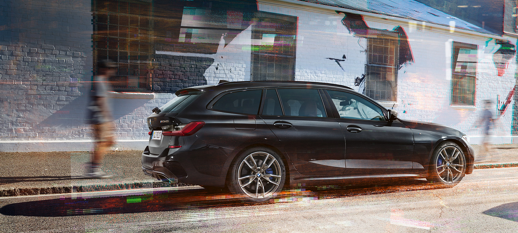 Sett fra siden BMW M340i xDrive Touring (G21) BMW M340i xDrive Touring (G21) safirsort metallic sett fra siden på gaten