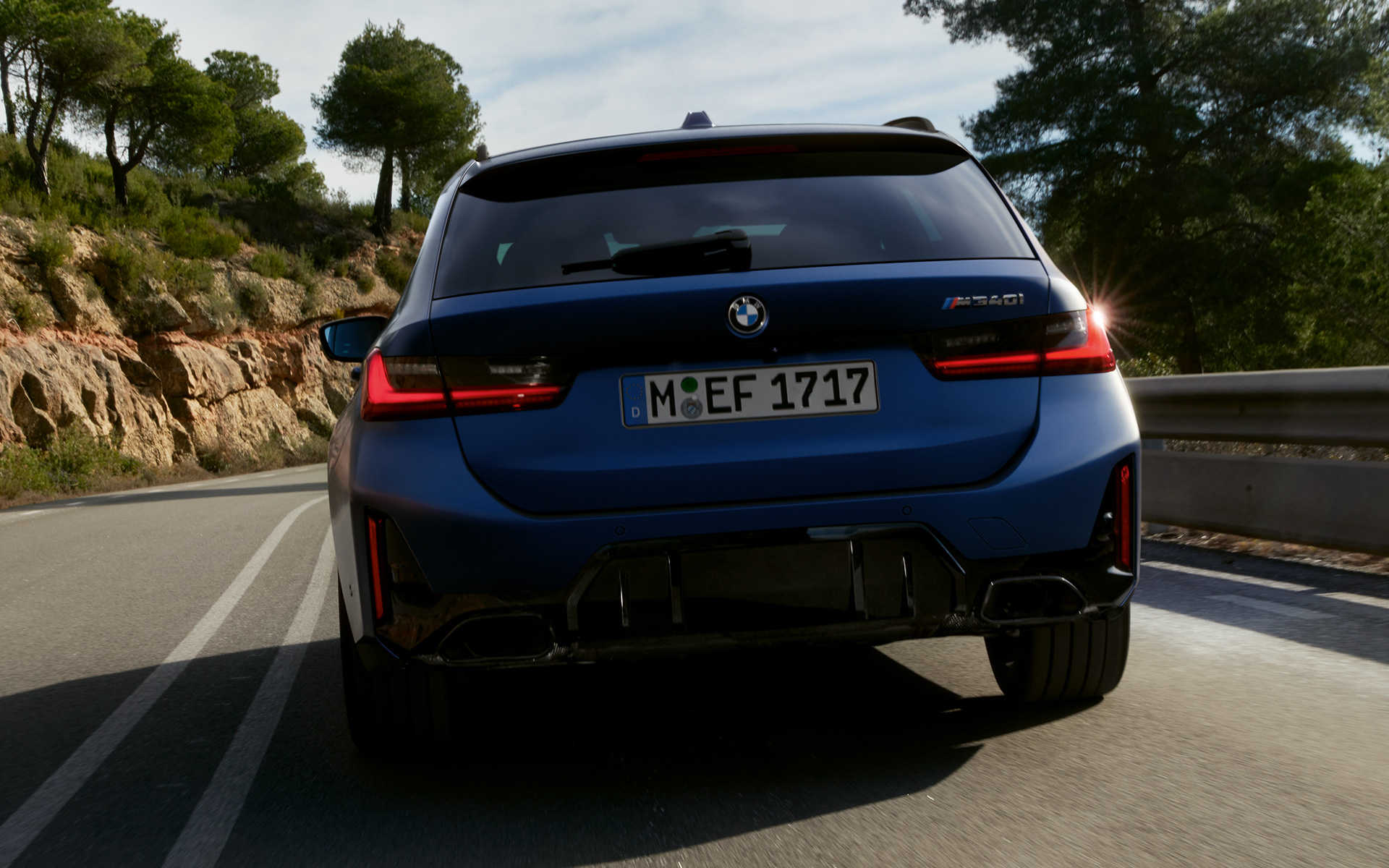 BMW M340i xDrive Touring G21 Frozen Tanzanite blå, sett kjørende på gaten bakfra