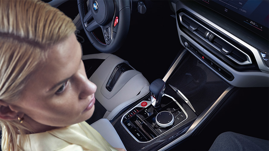 BMW M4 Competition Cabriolet med M xDrive G83 Interiør 2021 Midtkonsoll BMW M4 Competition Cabriolet med M xDrive G83 2021 Midtkonsoll og kvinne på passasjersetet