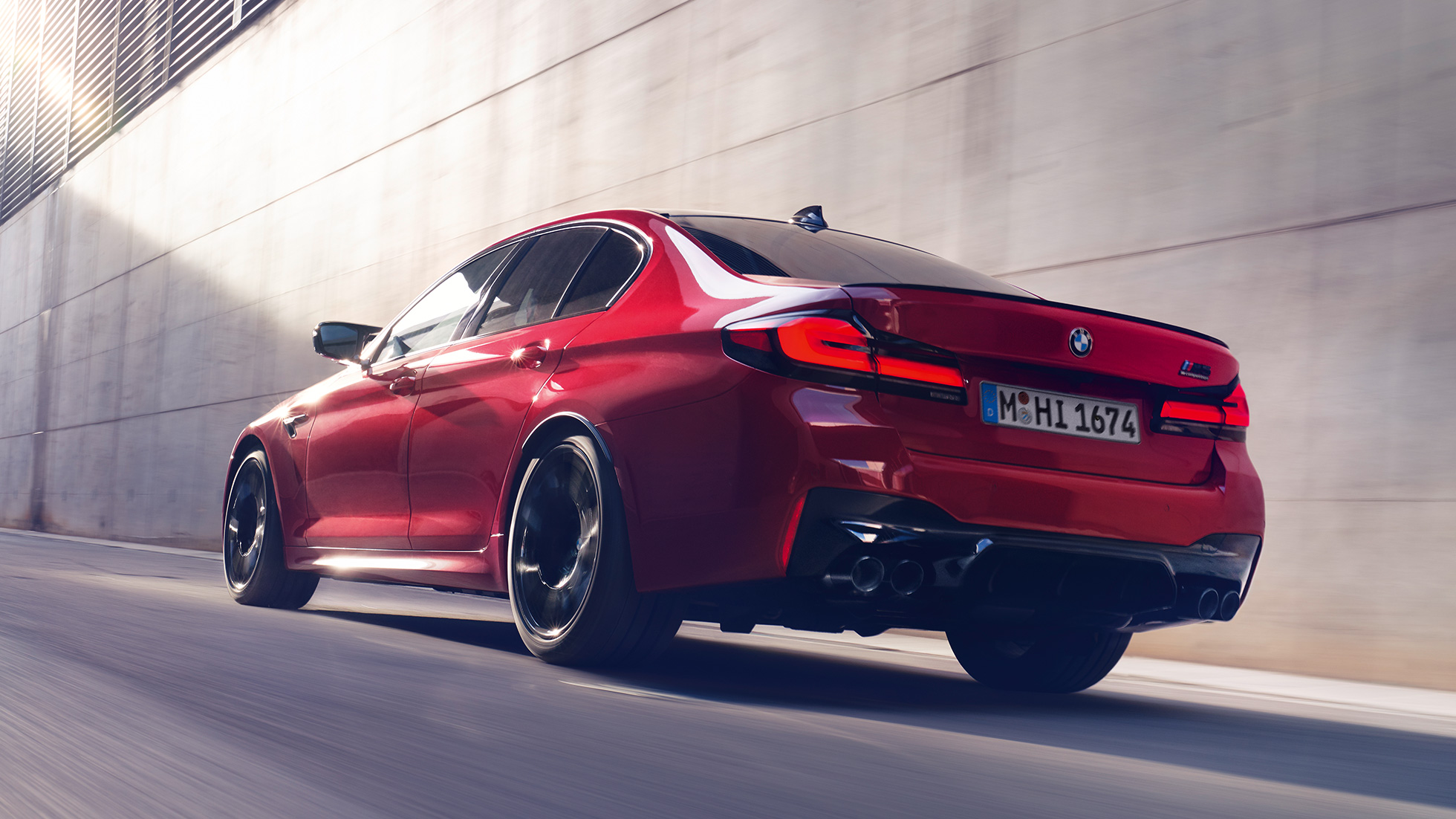 BMW M5 Competition F90 LCI Facelift 2020 sett skrått bakfra BMW M5 Competition F90 LCI Facelift 2020 BMW Individual Imolarød sett skrått bakfra kjørende