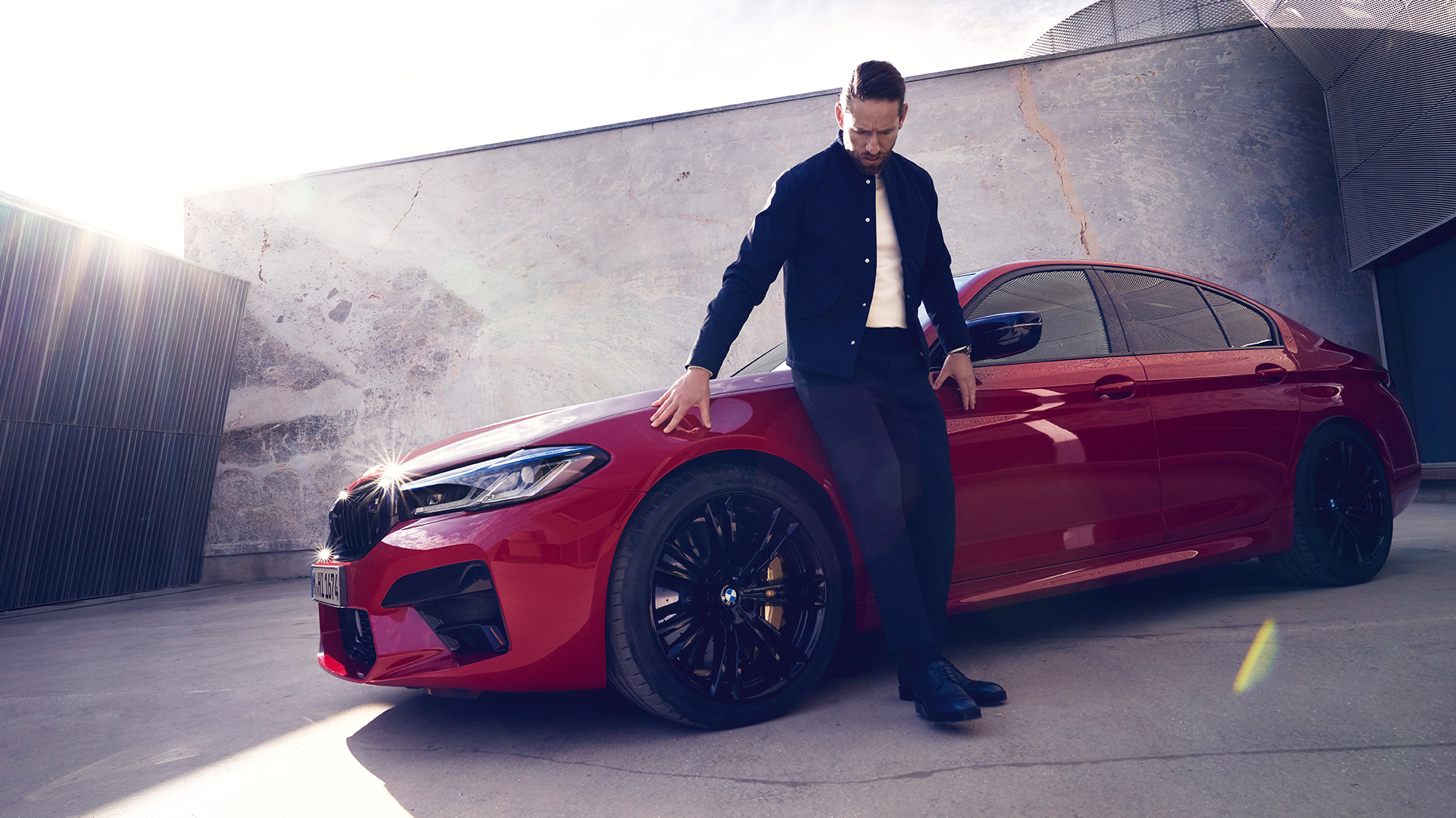 BMW M5 Competition F90 LCI Facelift 2020 sett fra siden med mann BMW M5 Competition F90 LCI Facelift 2020 BMW Individual Imolarød sett fra siden med mann