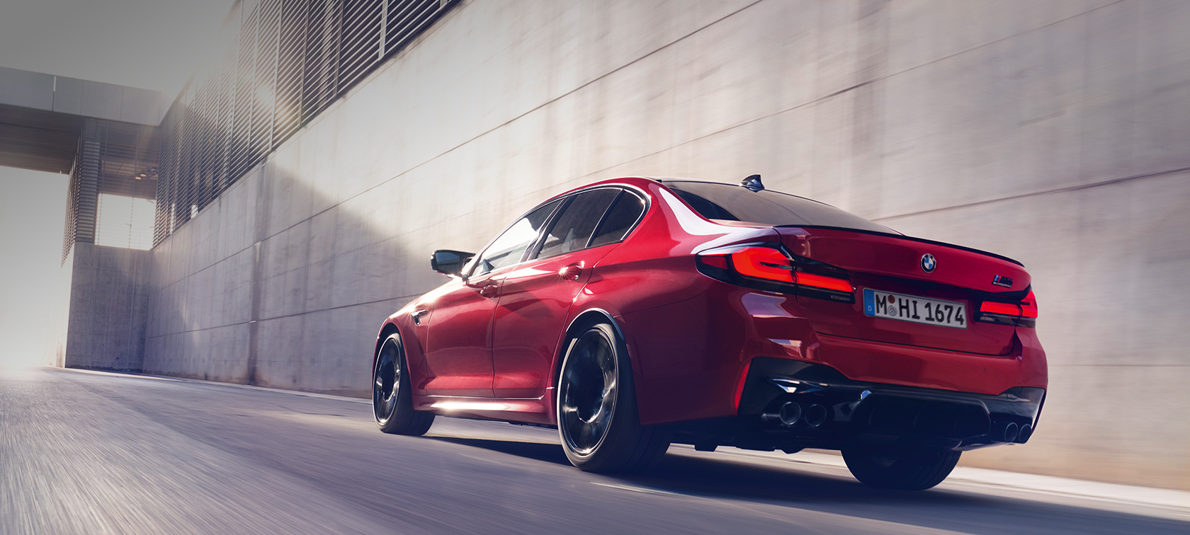 BMW M5 Competition F90 LCI Facelift 2020 sett skrått bakfra kjørende BMW M5 Competition F90 LCI Facelift 2020 BMW Individual Imolarød sett skrått bakfra kjørende