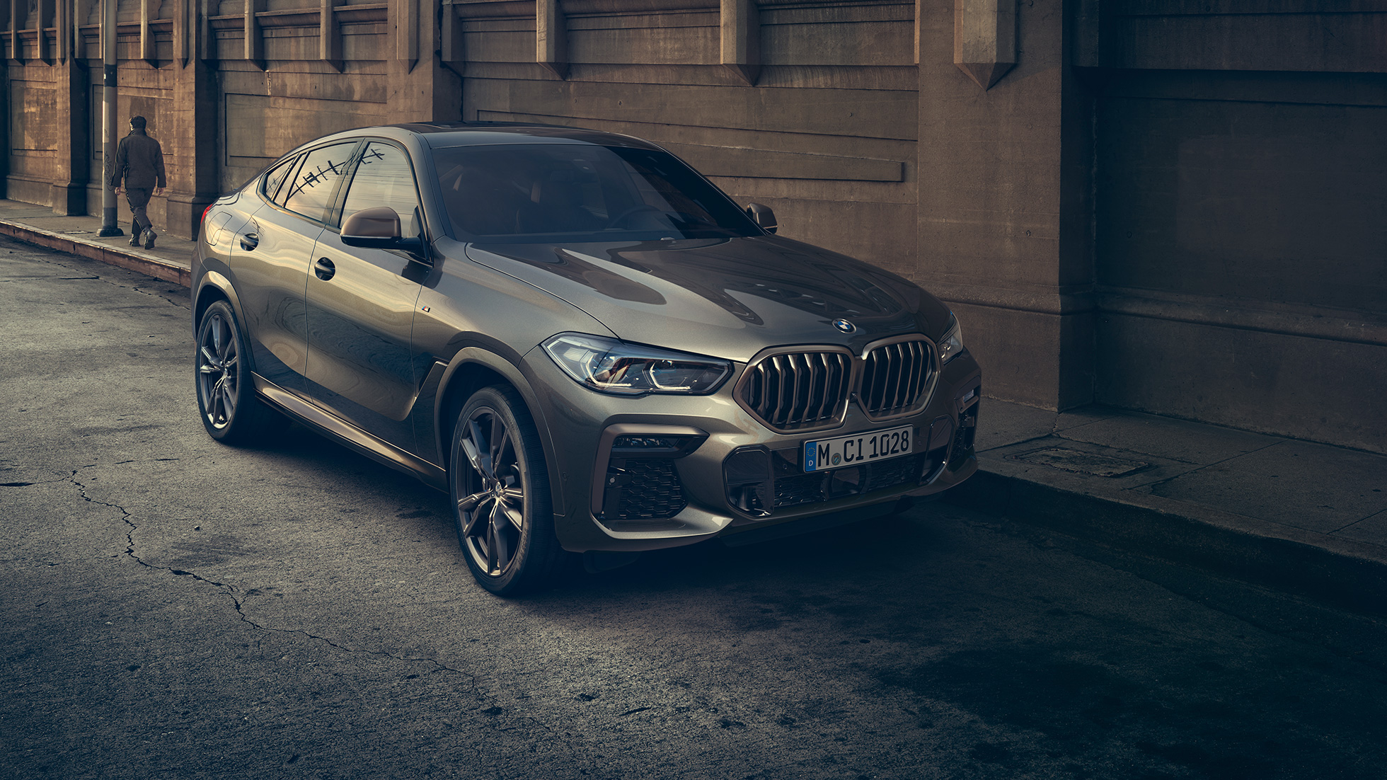 BMW X6 M50i standing. BMW X6 M50i sett forfra foran bylandskap.