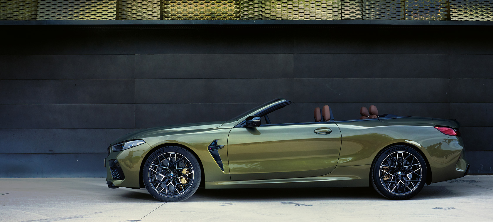 BMW M8 Competition Cabriolet F91 LCI Facelift 2022 sett fra siden stående BMW M8 Competition Cabriolet F91 LCI Facelift 2022 BMW Individual messing metallic sett fra siden, stående med åpen dør og kvinnelig modell