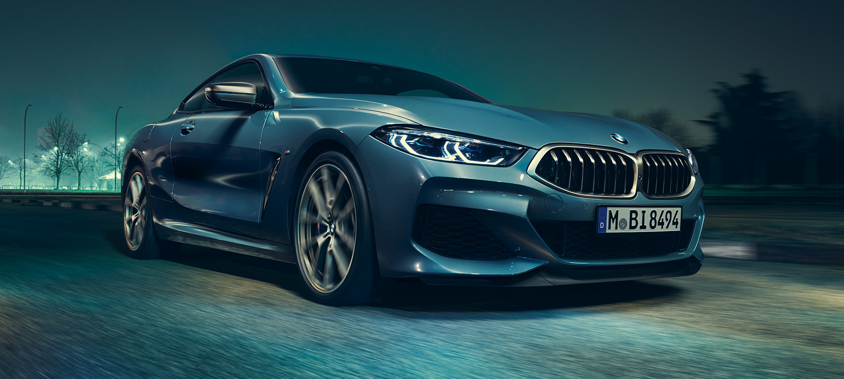 BMW M850i xDrive Coupé, sett skrått forfra. Kjørende BMW M850i xDrive Coupé i Barcelona blå metallic, sett skrått forfra.
