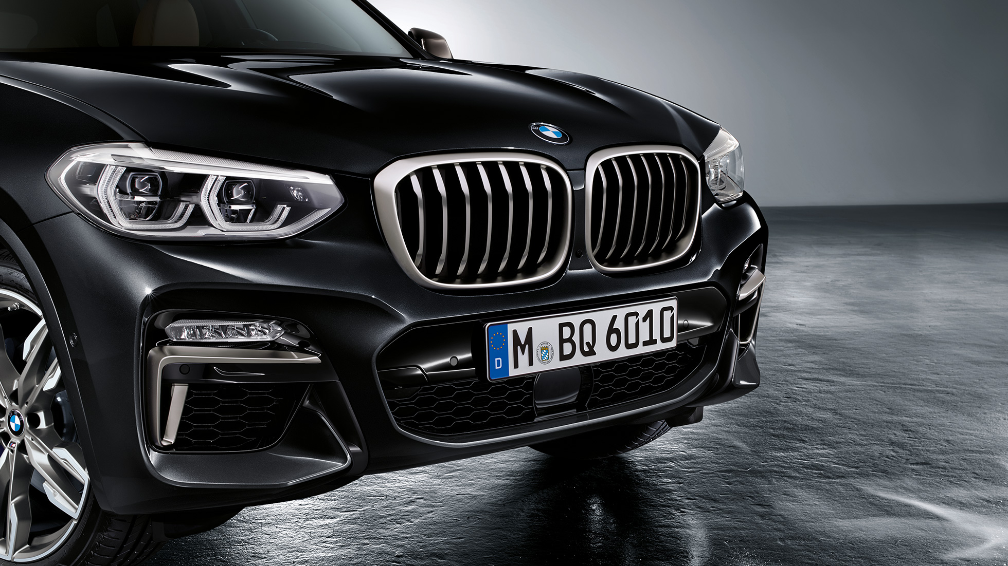 Fronten på BMW X3 M40i og BMW X3 M40d. Utvendig design på BMW X3 M40i og BMW X3 M40d i safirsort metallic med front med designelementer i ceriumgrått.