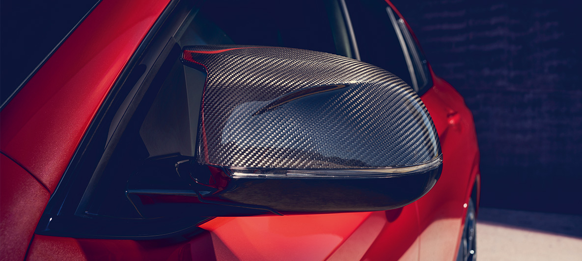 BMW X4 M Competition, speilhus i karbonfiber. Utvendig design på BMW X4 M Competition i torontorød metallic med M Carbon utvendig designpakke med speilhus i karbonfiber.