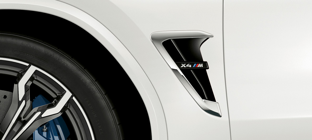 BMW X4 M med M gjeller. Utvendig design på BMW X4 M i alpinhvitt med M gjelle med kromdetaljer og modellbetegnelse.