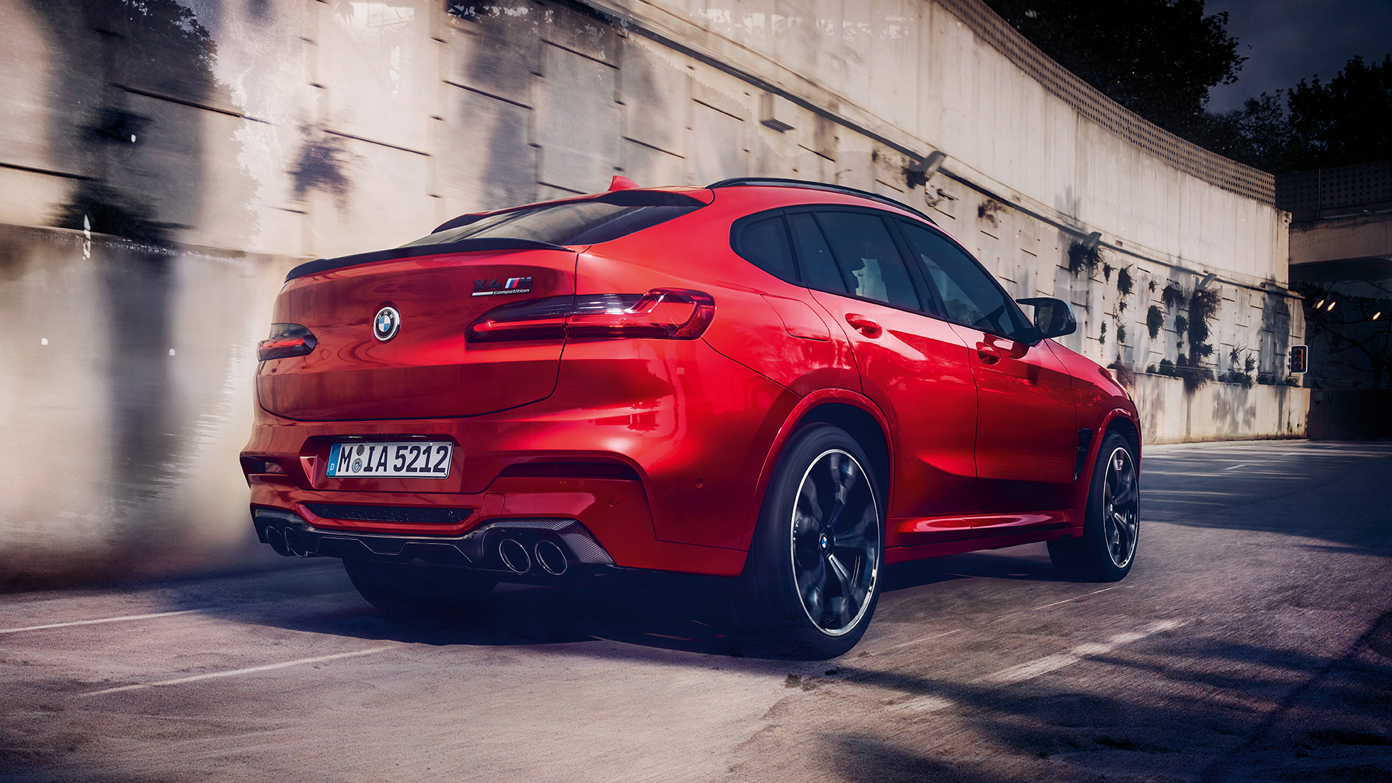 BMW X4 M Competition sett fra siden bak. Utvendig design på BMW X4 M Competition i torontorød metallic sett fra siden bak.