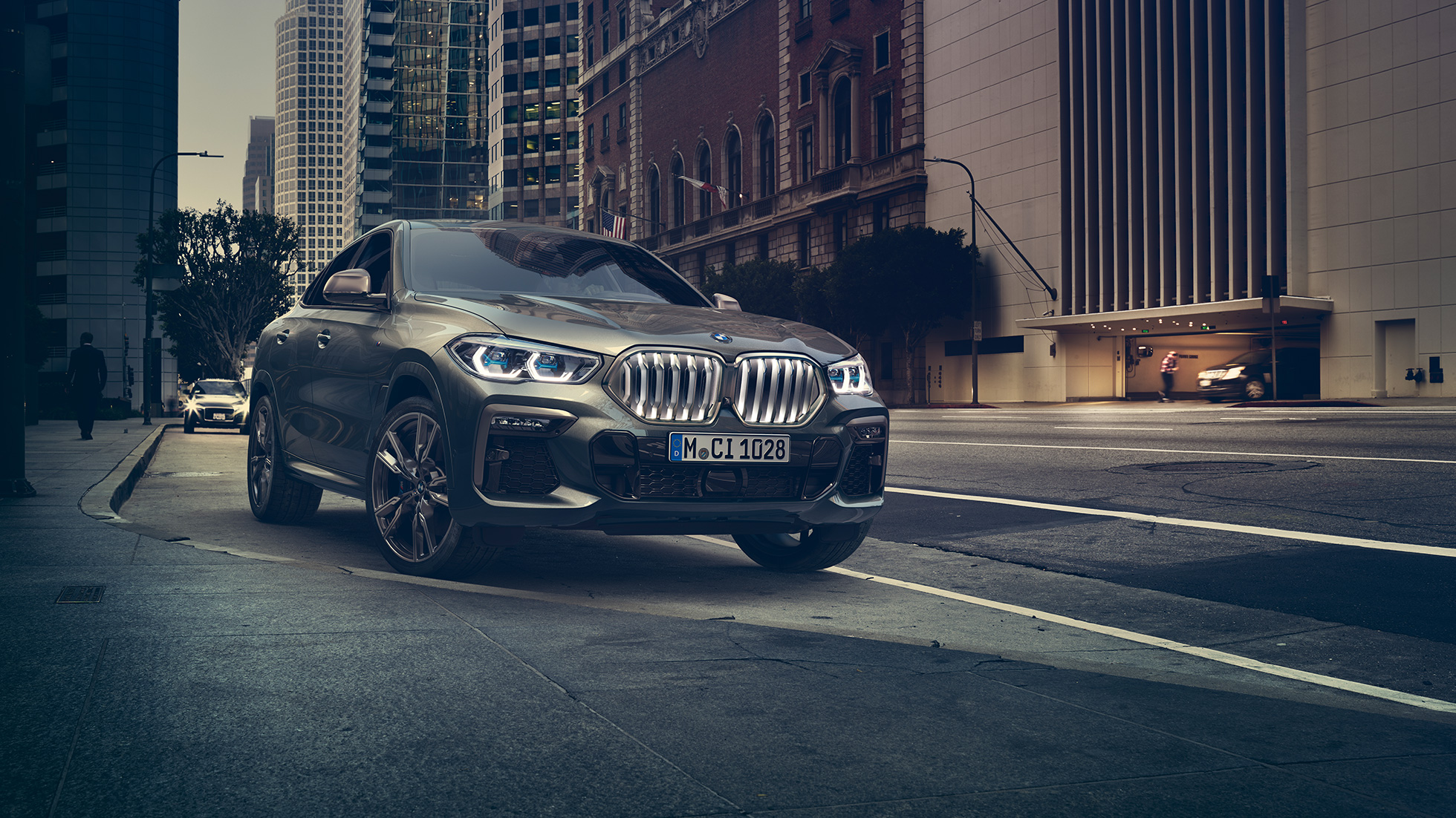 BMW X6 M50i stående BMW X6 M50i sett skrått forfra foran bylandskap