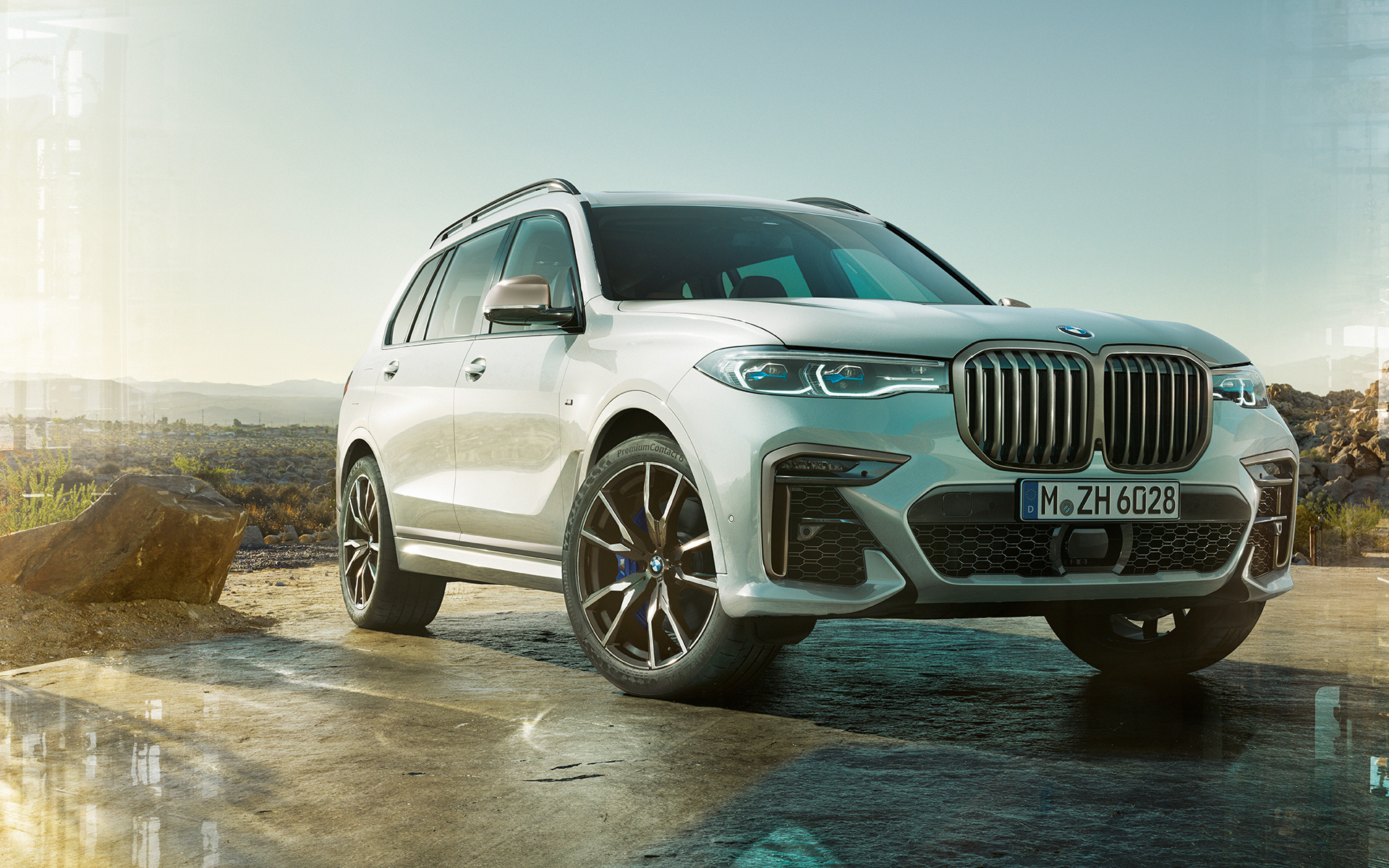 BMW X7 M50i G07 2019 Mineralhvit stående foran naturlandskap BMW X7 M50i G07 2019 Mineralhvit sett skrått forfra stående foran naturlandskap