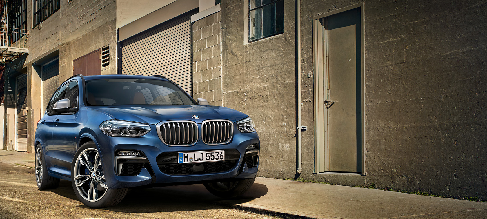 BMW X3 M40i som står foran en husvegg BMW X3 M40i som står foran en husvegg