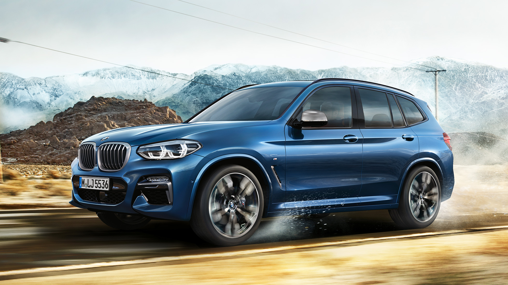 Halvtotal av felger og skjermer på BMW X3 M40i foran fjell Halvtotal av felger og skjermer på BMW X3 M40i foran fjell