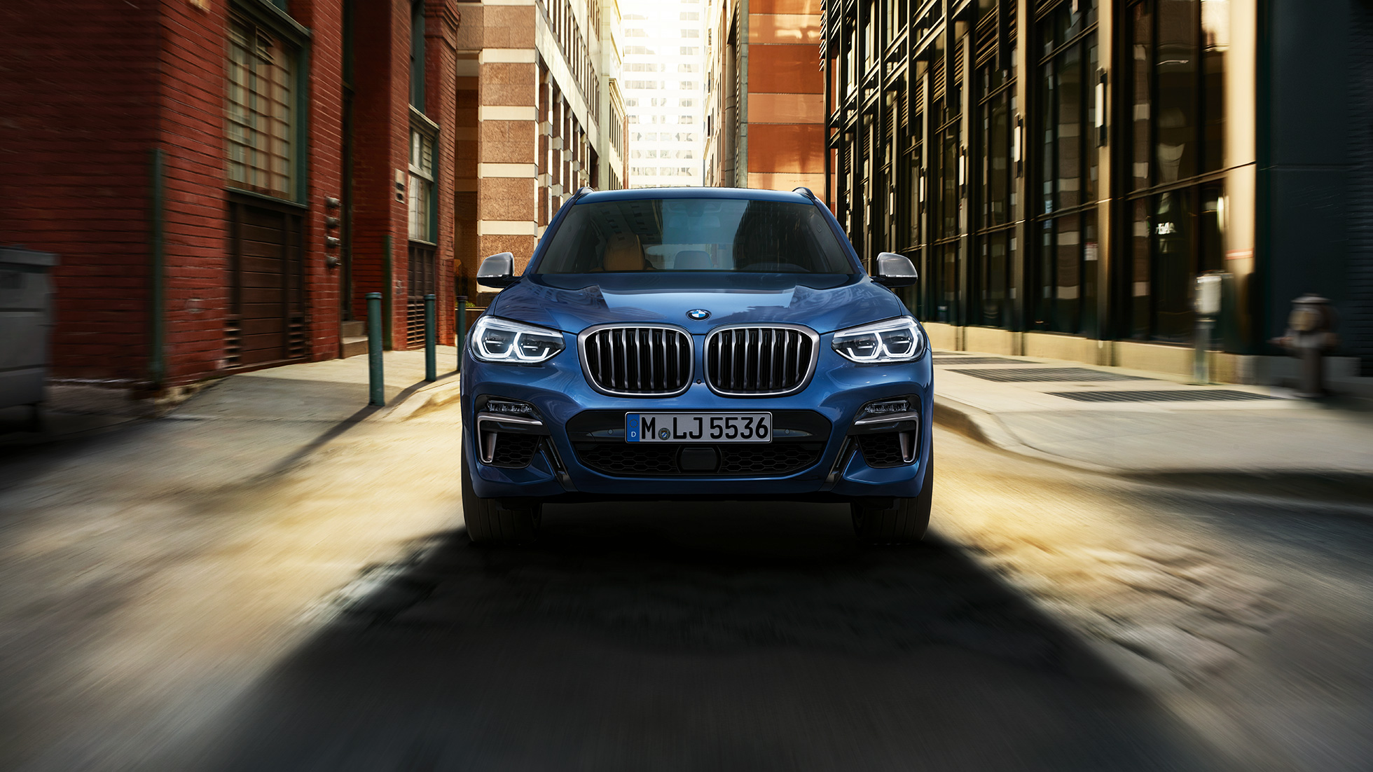 BMW X3 M40i sett forfra foran bylandskap BMW X3 M40i sett forfra foran bylandskap