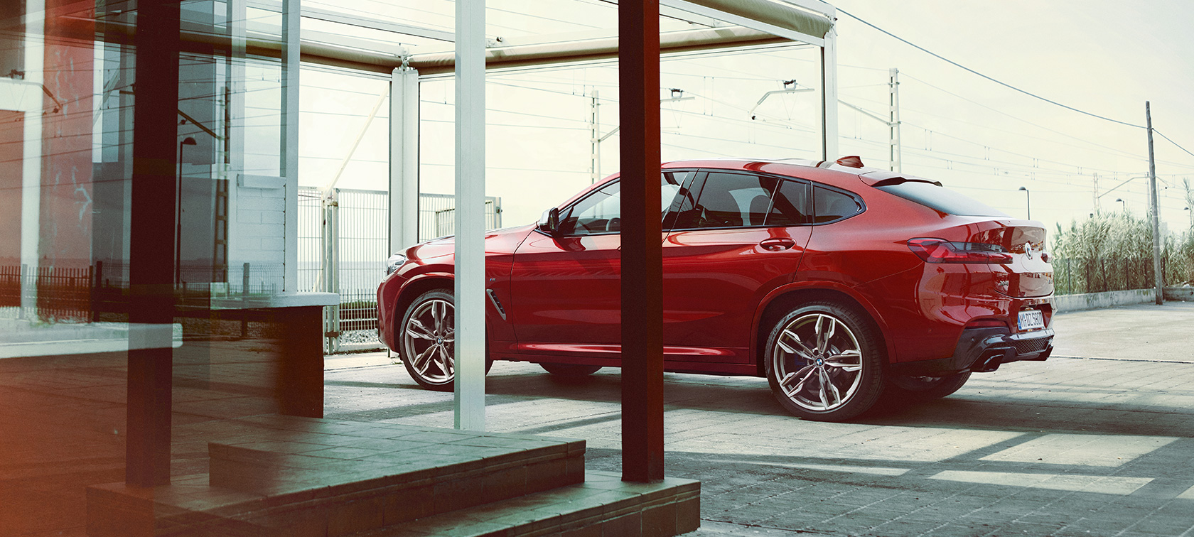 BMW X4 Sett fra siden BMW X4 M40i G02 2018 Flamencorød med briljanteffekt parkert