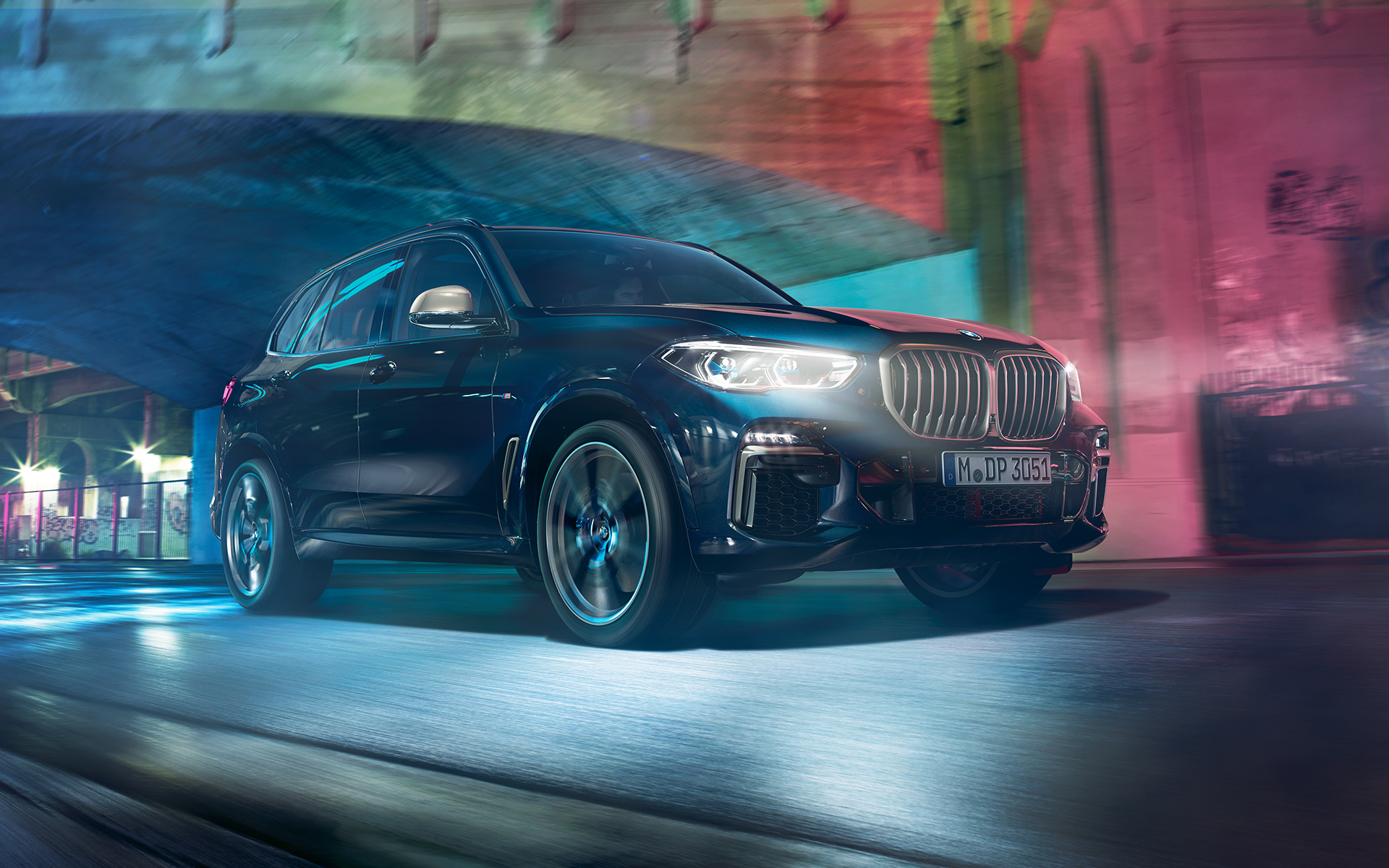 BMW X5 M50d i aksjon BMW X5 M50d kjører i bylandskap om natten