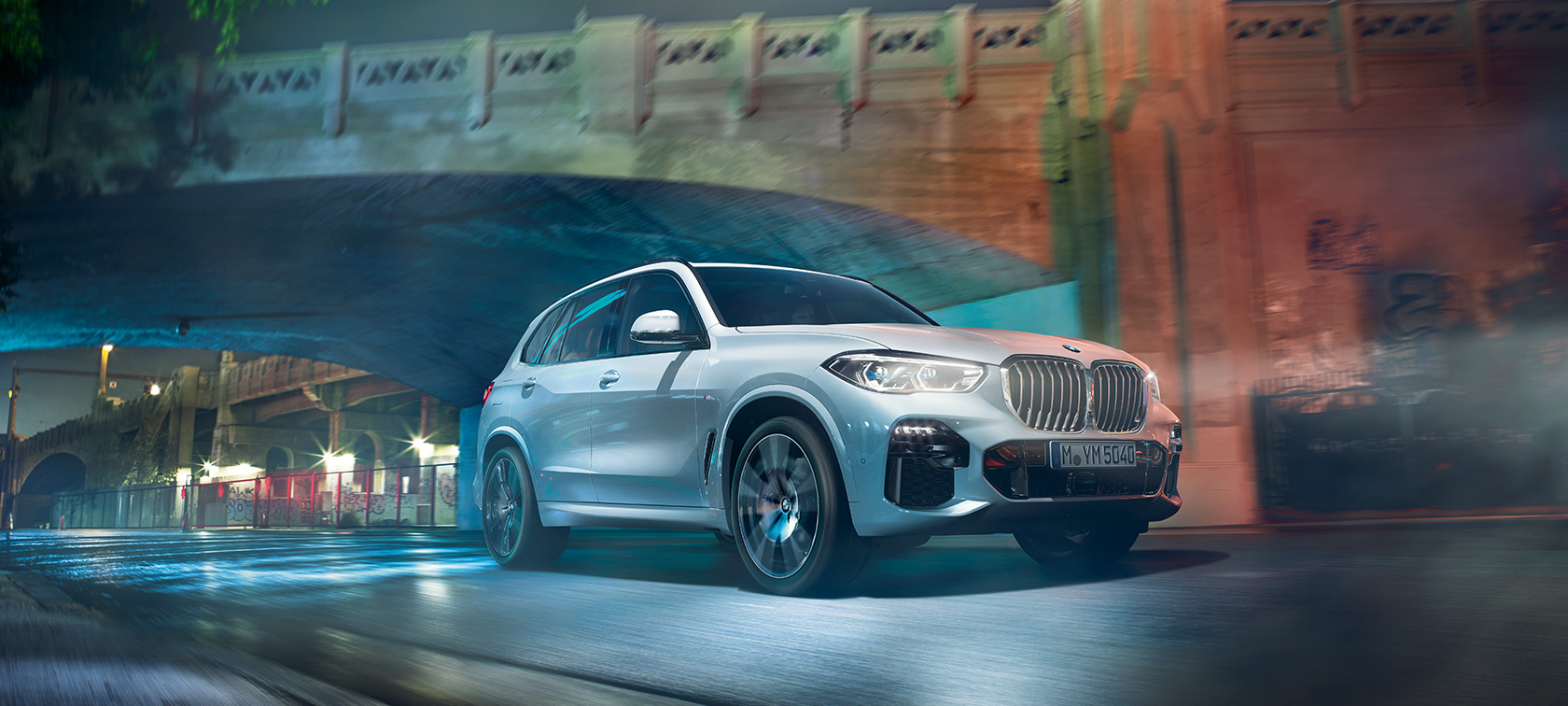 BMW X5 G05 2021 Mineralhvit metallic sett skrått forfra kjørende om natten