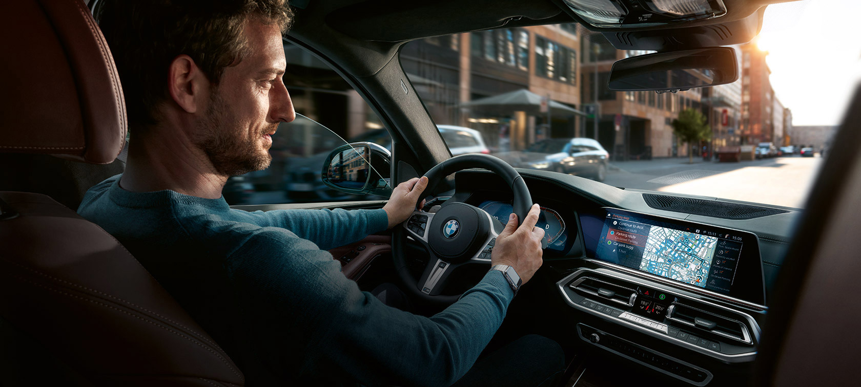 BMW Maps navigasjon Mann kjører i BMW med BMW Maps Navigation i kontrolldisplayet