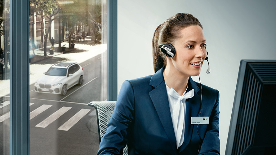Concierge service Concierge service: BMW-medarbeider sitter med headset foran skjerm