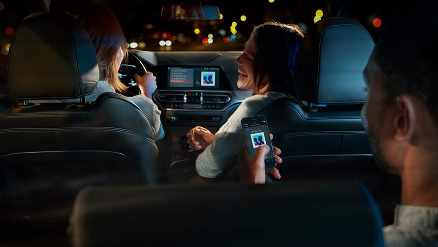 Connected Command Connected Command: tre personer sitter og hører på musikk i en BMW som kjører