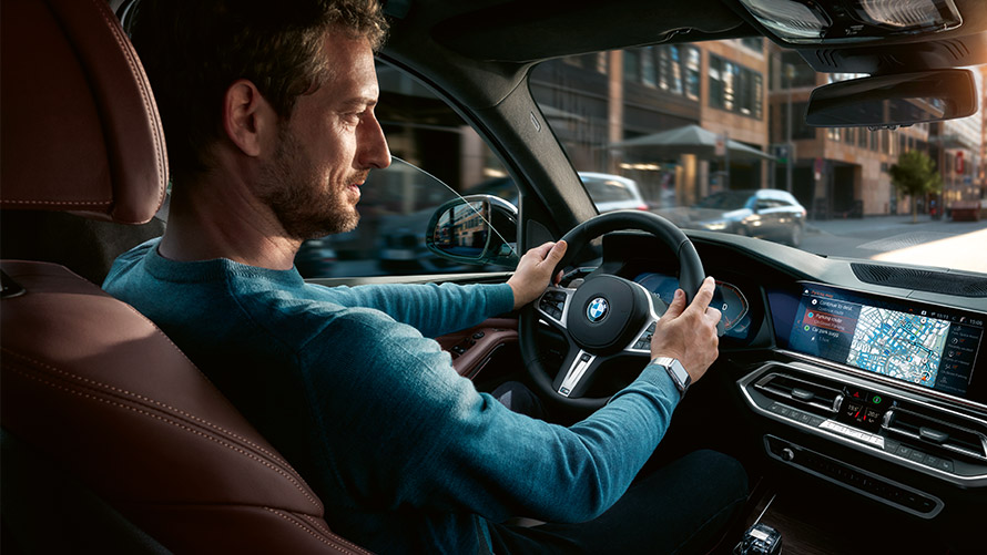 Parkeringsplassassistent En mann bruker parkeringsplassassistenten på skjermen i sin BMW
