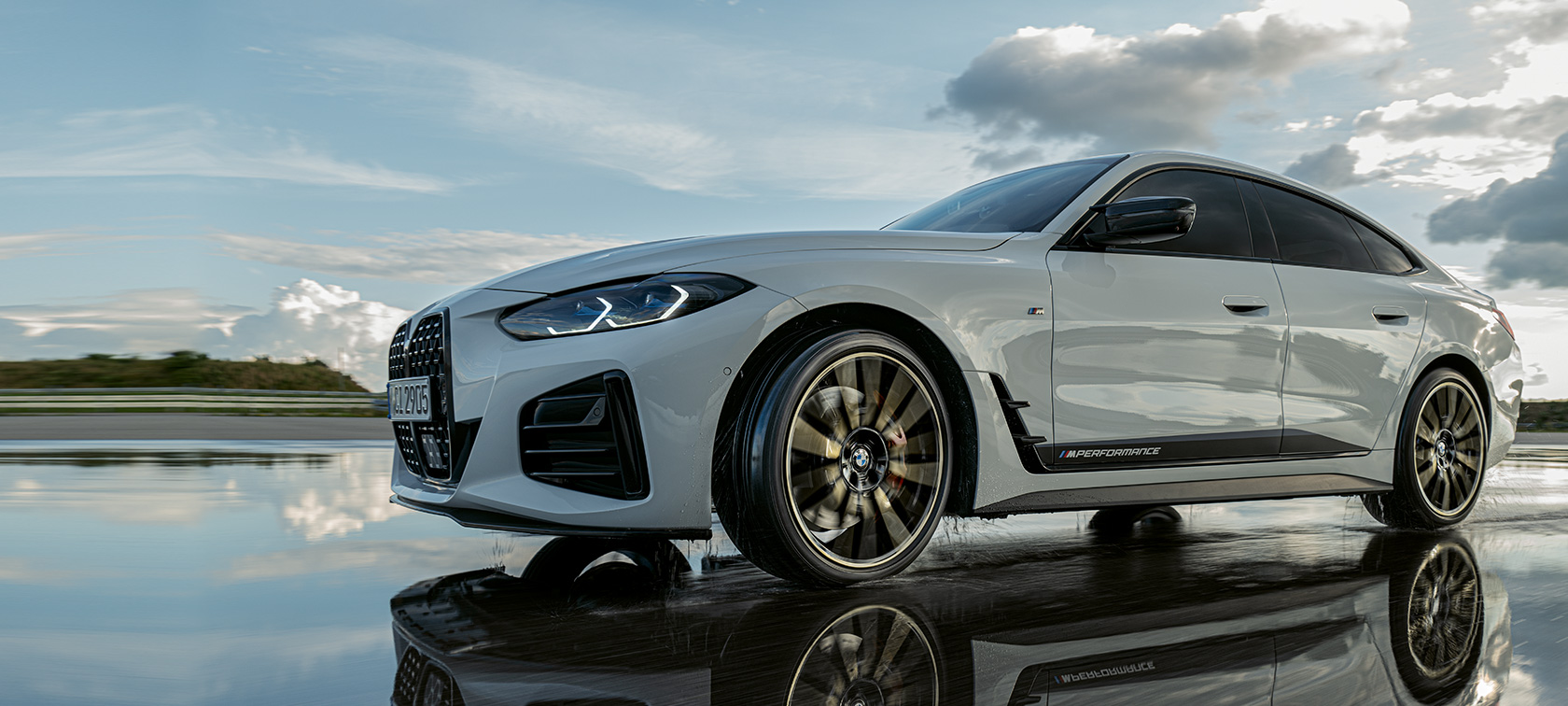 BMW 4-serie Gran Coupé (G26) med M Performance Parts kjørende på våt veibane BMW 4-serie Gran Coupé (G26) med M Performance Parts kjørende på våt veibane