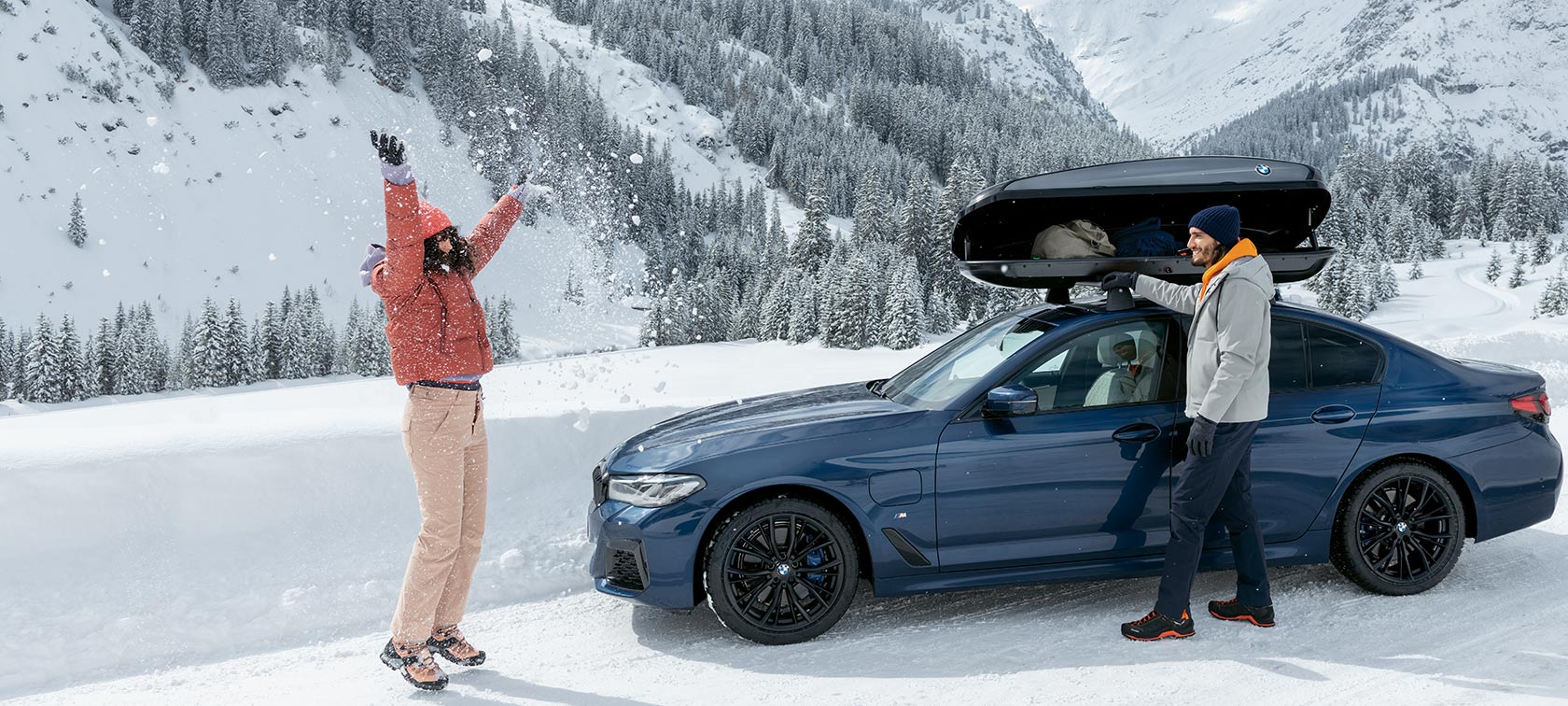 BMW originaltilbehør og BMW service for høst og vinter Leende kvinne og mann på akering i snøen