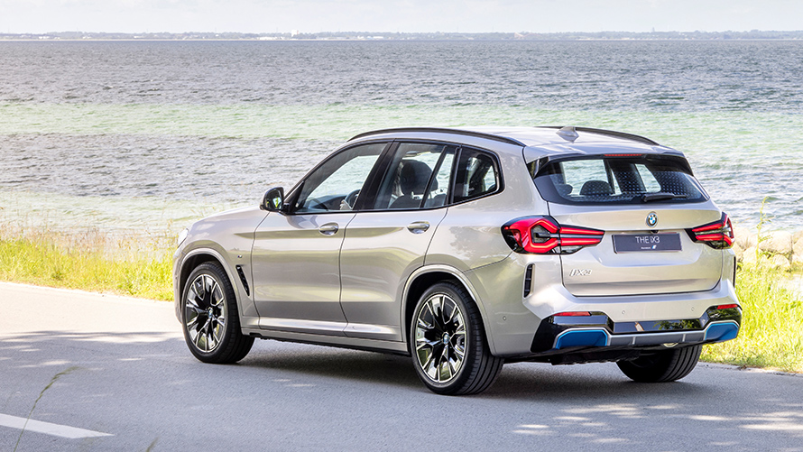 BMW iX3 med fyrhjulsdrift parkerad på landsväg. BMW iX3 med fyrhjulsdrift parkerad på landsväg.