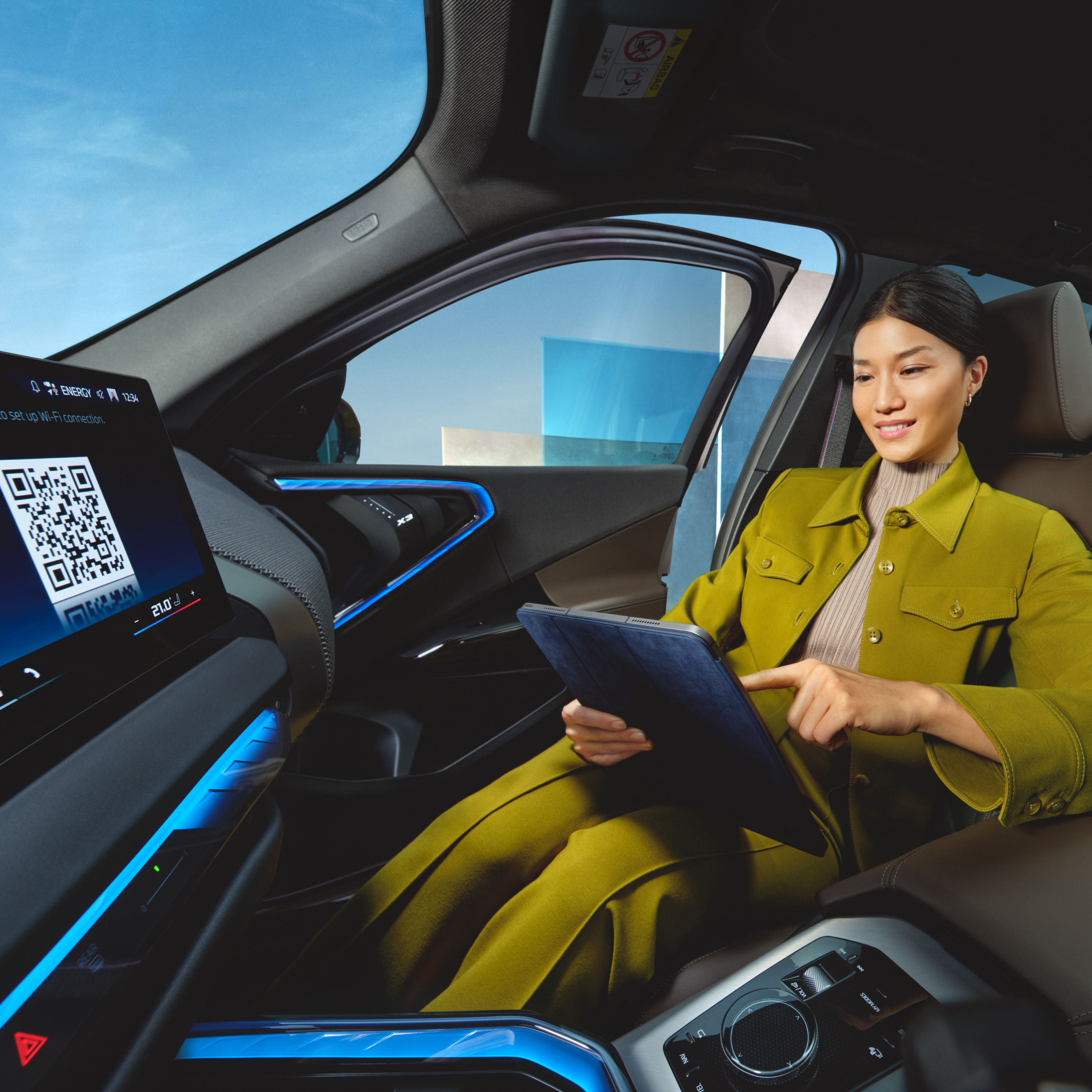 En personen bruker et nettbrett i en BMW
