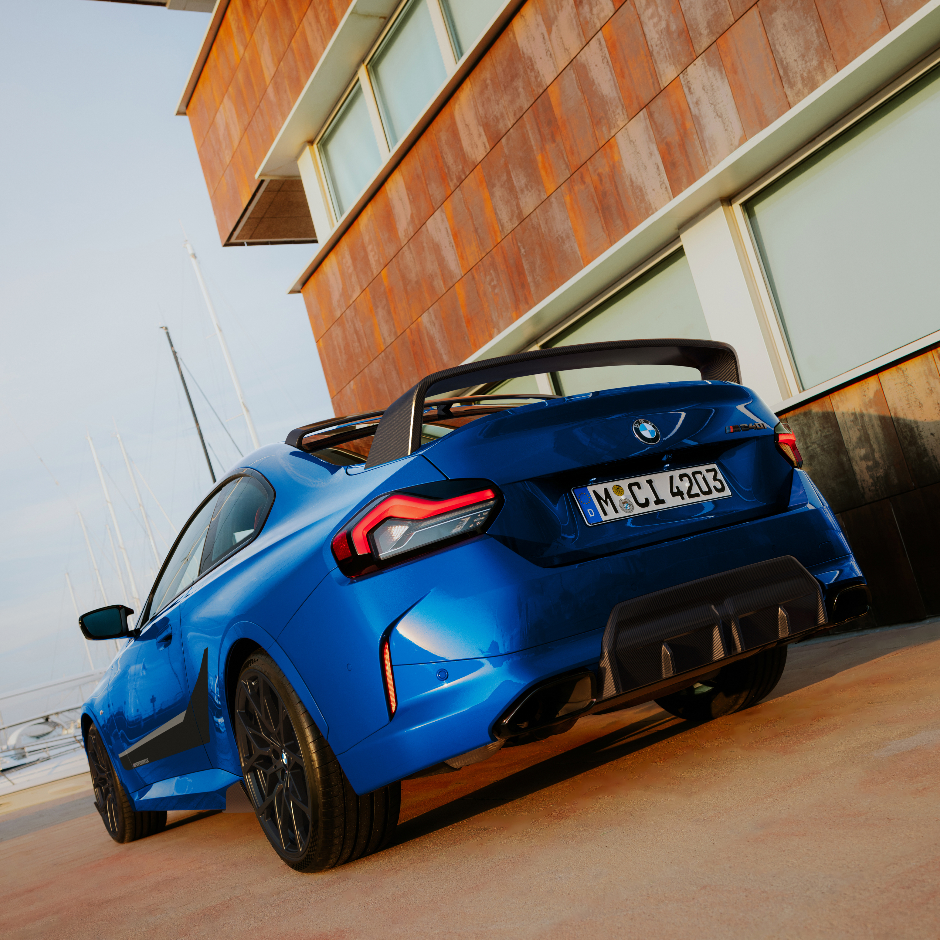 BMW med M Performance hekkspoiler står parkert foran et hus