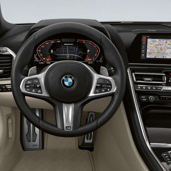 Førerplass med M skinnratt i BMW M850i xDrive i dravittgrå metalliclakk.