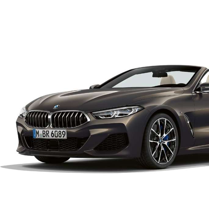 BMW M850i xDrive i dravittgrå metalliclakk sett skrått forfra.