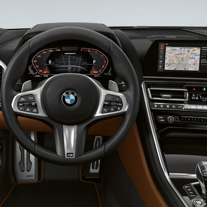 Førerplass med M skinnratt i BMW M850i xDrive i mineralhvit metalliclakk. Førerplass med M skinnratt i BMW M850i xDrive i mineralhvit metalliclakk.